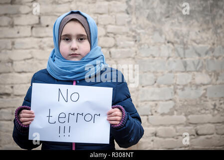 Fille de réfugiés avec une inscription sur une feuille blanche 'pas de terrorisme" Banque D'Images