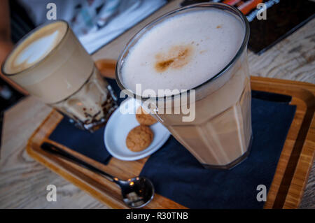 Deux verres d'un Latte Macchiato servi sur une plaque avec les cookies. Banque D'Images