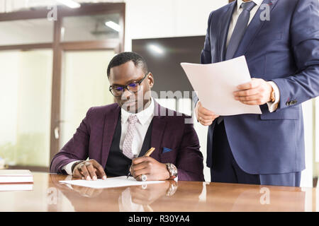 African American man signature contrat, homme noir part mettre la signature le document officiel, les clients clients biracial couple faire acheter ou connexion Banque D'Images