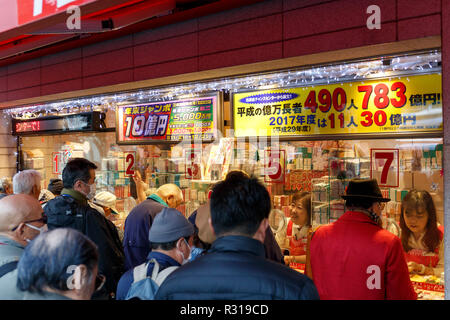 Les gens achètent des billets de loterie sur la première journée de vente pour la fin de l'exercice annuel de loterie jumbo le 21 novembre 2018, Tokyo, Japon. Tôt le matin les gens alignés pour acheter leurs billets de loterie à la 1ère fenêtre ticket à Ginza, qui est bien connue pour produire des grands gagnants. Cette année, le premier prix est de 1 milliards de yens (env. US$ 8,9 millions) et chaque ticket coûte 300 yen (US$ 2,65). Les ventes de billets continuent à travers le pays jusqu'au 21 décembre. Credit : Rodrigo Reyes Marin/AFLO/Alamy Live News Banque D'Images