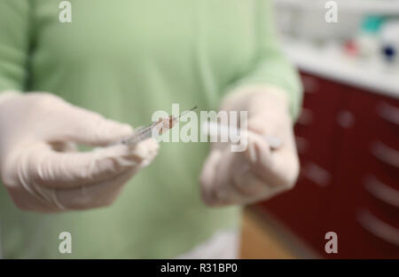 ILLUSTRATION - 21 novembre 2018, la Bavière, Würzburg : un assistant du médecin tient une seringue avec la quadruple le vaccin contre la grippe Influvac Tetra (illustration sur le thème de la vaccination antigrippale) dans un cabinet de médecin. Photo : Karl-Josef Opim/dpa Banque D'Images