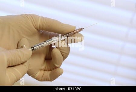 ILLUSTRATION - 21 novembre 2018, la Bavière, Würzburg : un assistant du médecin tient une seringue avec la quadruple le vaccin contre la grippe Influvac Tetra (illustration sur le thème de la vaccination antigrippale) dans un cabinet de médecin. Photo : Karl-Josef Opim/dpa Banque D'Images