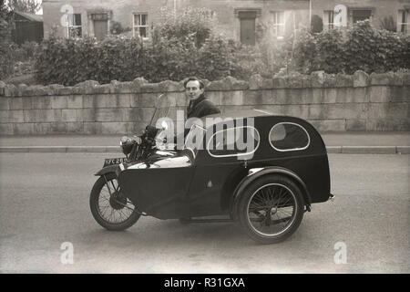 1950, historiques, l'homme sur la moto avec sidecar Watsonian 'couverte'. Dans les années 40 et 50, cette forme de transport, souvent appelé une "combinaison" ou "', était une méthode populaire de transporter un passager jusqu'à la croissance de la voiture particulière dans la dernière partie de la décennie. Eastablished en 1912, les Britanniques Watsonian side-car en fait, Birmingham salue était le plus populaire d'un side-car à l'époque. Banque D'Images