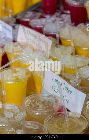 Sélection de jus de fruits naturels faits à la main avec des pailles à la vente à un décrochage de jus à un marché de fruits et légumes dans le centre de Londres. Banque D'Images