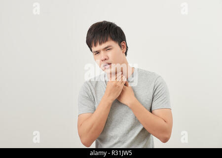 Jeune homme asiatique ayant mal de gorge / maladies liées à la gorge Banque D'Images