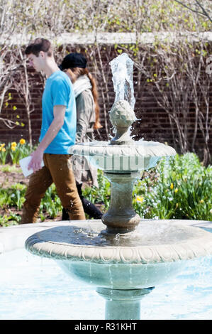 Un jeune couple en passant devant une fontaine décorative. Banque D'Images