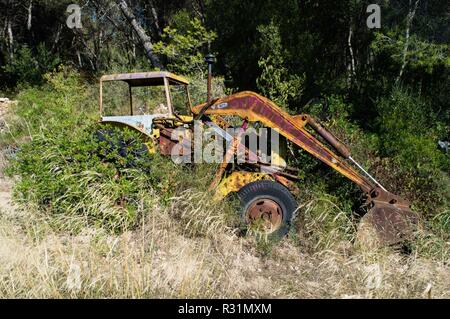 Tracteur abandonné garées en champ envahi Banque D'Images