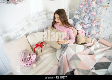 Petite fille se détendre à la maison. Noël famille vacances. bonne année. Les achats de Noël. petit enfant fille avec cadeau de Noël. Le matin avant Noël. Le Sommeil. en attente de santa. L'hiver. Regarder ça. Banque D'Images