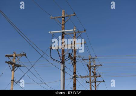 Infrastructure de distribution de réseau électrique, rangée de poteaux de services publics et lignes électriques haute tension avec un ciel bleu dans le Dakota du Sud, États-Unis Banque D'Images