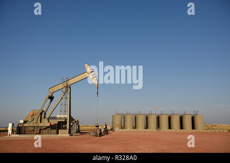 Site de puits de pétrole brut, cric à pompe, réservoirs de stockage de production, ciel bleu, schiste de Niobrara, Wyoming, avec espace de copie Banque D'Images