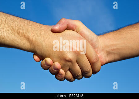 Handshake against blue sky Banque D'Images