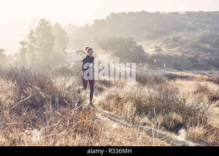 Beau portrait femme blanche s'exécute sur le sentier dans la lumière du soleil du matin Banque D'Images