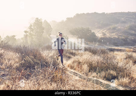 Beau portrait femme blanche s'exécute sur le sentier dans la lumière du soleil du matin Banque D'Images