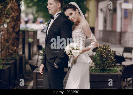 La mariée et le marié à marcher le long des rues ensoleillées Banque D'Images