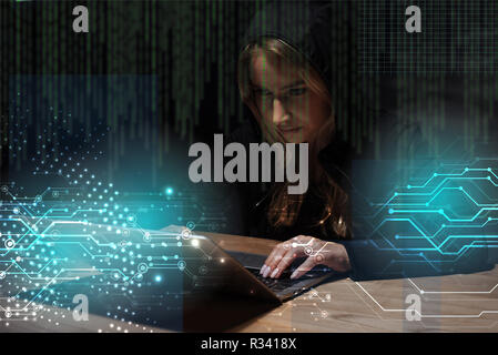 Portrait of woman in black hoodie using laptop, cyber security concept Banque D'Images