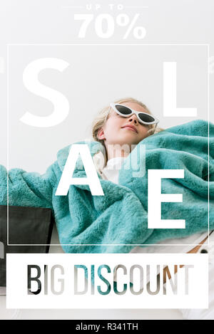 Belle enfant élégant manteau de fourrure turquoise en couchant avec sac shopping noir sur blanc, big discount vente bannière concept Banque D'Images