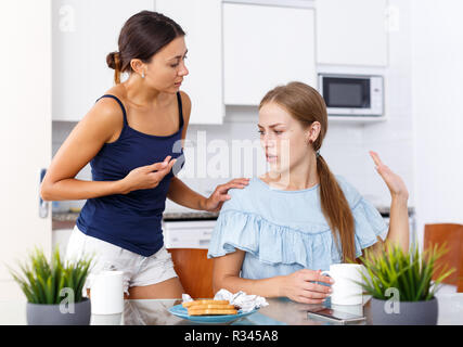 Portrait de deux jeunes filles offensé après querelle dans cuisine intérieur Banque D'Images