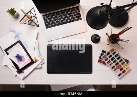 Office de bureau avec ordinateur portable, tablette graphique, le stylo et le matériel d'art, télévision lay Banque D'Images