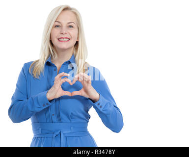 Friendly smiling middle aged woman in blue dress regarde la caméra et montre un geste je vous aime isolé sur fond blanc. Banque D'Images