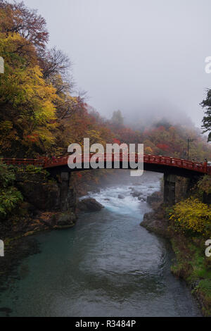 Regardant le magnifique pont Shinkyo à Nikko, Japon sur une journée d'automne brumeux, avec des pics de la couleur de l'automne. Banque D'Images