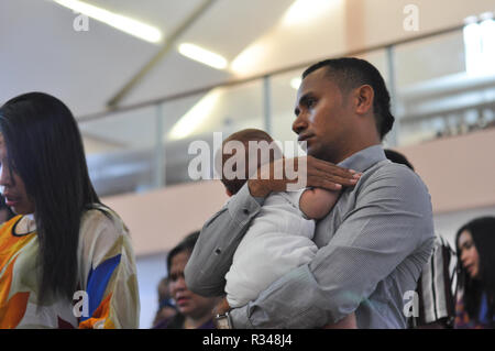 Batam, Indonésie. Un homme tenir son enfant dans une procession de baptême. Banque D'Images