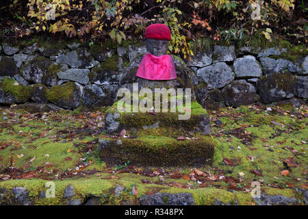 Statues Jizo sacré line un chemin le long des rives de la rivière Daiya vers un temple bouddhiste à Nikko, Japon pendant les heures de la couleur de l'automne. Banque D'Images