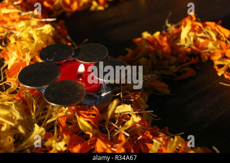 Diya allumé placé sur fleur avec des pièces de monnaie pour célébrer diwali festival dhanteras et en Inde Banque D'Images