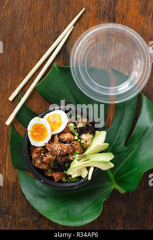 Deux poke bol de riz frit, viande de poulet, d'avocat et oeufs dans le fort sur woocen Vue de dessus de table. Concept asiatique à emporter Banque D'Images