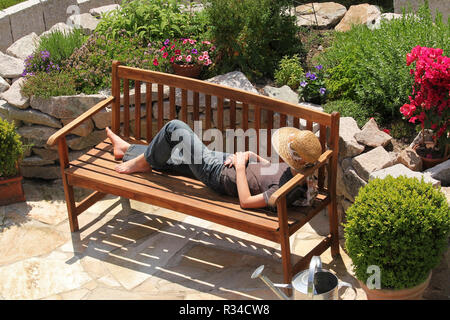 Se détendre sur un banc de jardin Banque D'Images