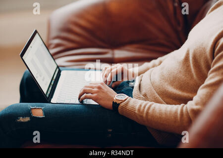 Jeune homme travaillant sur un ordinateur portable Banque D'Images