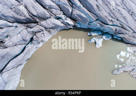 Vue du dessus du glacier, crevasses et le lac glaciaire. Banque D'Images