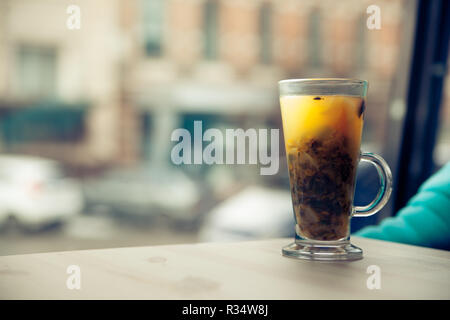 Tasse transparente avec argousier plateau se dresse sur une table en bois dans un café Banque D'Images