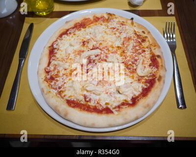 Pizza au fromage se trouve sur la table avec une fourchette et couteau. Banque D'Images