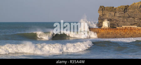 Deux grandes vagues de s'écraser dans le mur du port à Portreath, entraîné par le vent en plein soleil. Banque D'Images