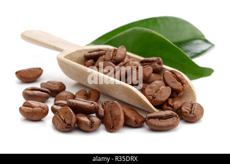 Grains de café dans la cuiller à bois feuilles isolées sur fond blanc Banque D'Images