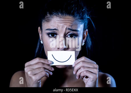 Close up portrait dramatique de femme triste de se cacher sa dépression avec sourire peint sur papier dans l'émotion humaine souffrant en silence la dépression iso concept Banque D'Images