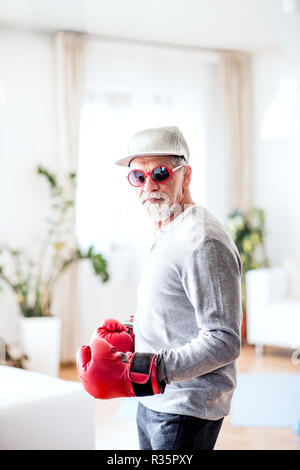 Un homme avec des gants de boxe s'amusant à la maison. Banque D'Images