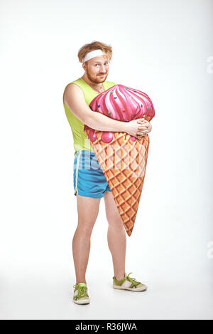 Aux cheveux rouges, barbu, joufflu l'homme est maintenant un grand ice cream Banque D'Images