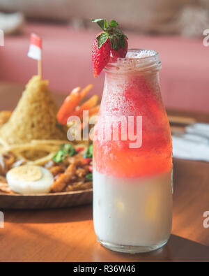 Smoothie fraise Milk Shake dans la bouteille avec l'arrière-plan flou pour Tumpeng Nasi de célébration et d'hôtes Banque D'Images