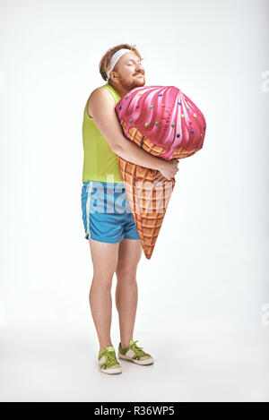 Aux cheveux rouges, barbu, joufflu l'homme est maintenant un grand ice cream Banque D'Images