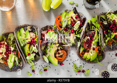 Tacos vegan sans gluten de haricot noir avec de la tomate et d'avocat salade avec sauce tahini et graines de grenade. saine restauration rapide pour l'ensemble de la famil Banque D'Images