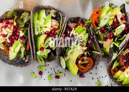 Tacos vegan sans gluten de haricot noir avec de la tomate et d'avocat salade avec sauce tahini et graines de grenade. saine restauration rapide pour l'ensemble de la famil Banque D'Images