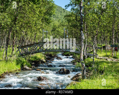 Pont de bois sur un chemin de randonnée traverse une petite rivière, randonnée le long de la vallée du glacier Steindalen Steindalsbre, Alpes de Lyngen, au sud du pays, Lyngseidet Troms Banque D'Images