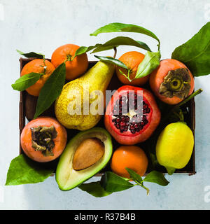 Différents fruits de grenade, poire, mandarine, citron, l'avocat et à la noix de coco de kaki sur la table. base d'une alimentation saine et de jus tous les jours je Banque D'Images
