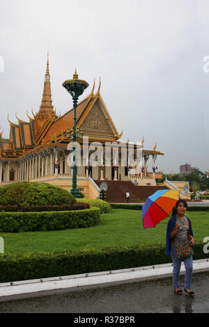 Fille avec un parapluie coloré à l'extérieur de la salle du trône (Preah Timeang Vinicchay Tevea), du Palais Royal, Phnom Penh, Cambodge Banque D'Images