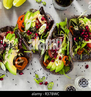 Tacos vegan sans gluten de haricot noir avec de la tomate et d'avocat salade avec sauce tahini et graines de grenade. saine restauration rapide pour l'ensemble de la famil Banque D'Images