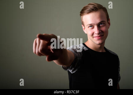 Beau jeune homme aux cheveux blonds contre l'arrière-plan de couleur Banque D'Images