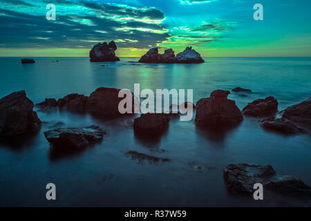 Belle seascape avec des pierres sur l'avant-plan dans moonlight Banque D'Images