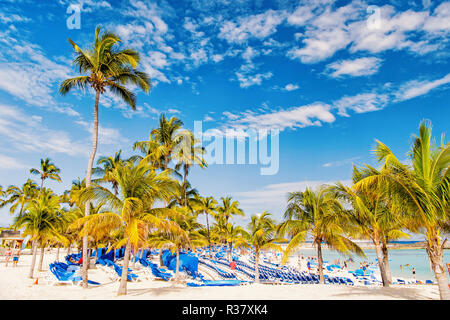 Great Stirrup Cay, Bahamas - 8 janvier 2016 : vert palmiers sur la plage de sable blanc avec chaises longues, les gens et la mer turquoise de l'océan ou sur la journée ensoleillée sur ciel bleu. Des vacances d'été, resort. Paradise Banque D'Images