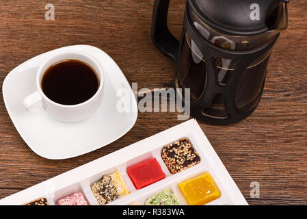 Du café noir et loukoum dans une boîte sur une table en bois Banque D'Images